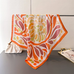 Vue détaillée du foulard carré en soie avec imprimé floral corail et aspect brillant