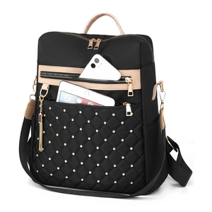 Quilted black nylon backpack with beige handles, gold studs and large interior capacity