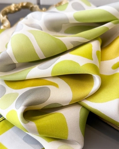 Détail d'un foulard en soie avec imprimé corail abstrait citron vert et texture satinée