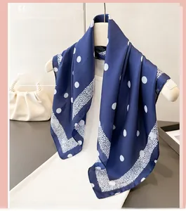 Détail d'un foulard en soie bleu marine à pois sur cintre avec fond sac en perles