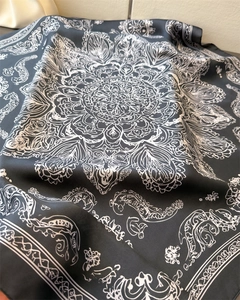 Detail of silk-like square scarf featuring elegant black and white mandala floral pattern