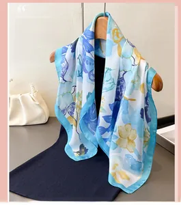 Detail of floral silk scarf with elegant blue and yellow prints on wooden hanger
