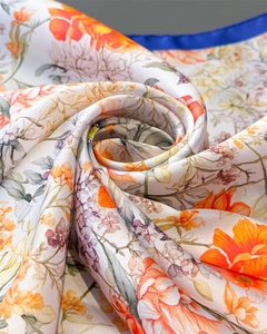 Detail of floral printed silk scarf showing intricate vibrant patterns and soft texture
