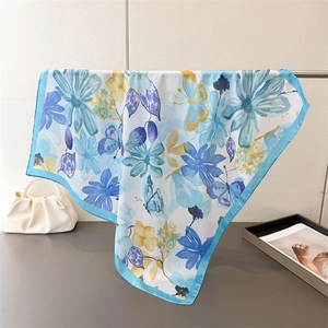 Close-up of lightweight silk-like floral square scarf with blue butterfly patterns