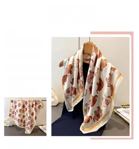Close-up of vintage silk scarf featuring brown elephant prints and chain patterns