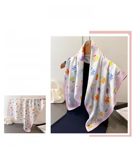 Detailed view of floral silk scarf featuring vibrant small flowers and pink stitched edges