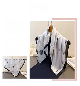 Détail d'un foulard en soie à motif floral gris élégant et bordure noire large