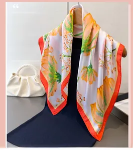 Close-up of floral silk scarf styled with a black dress and pearl handbag
