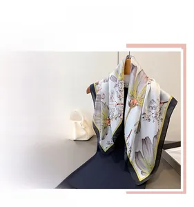 Close-up of elegant floral silk scarf with light blue patterns and glossy satin texture