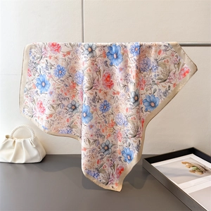 Detail of floral printed satin square scarf with champagne hem and smooth texture