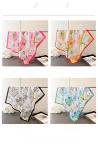 Detail display of four floral silk square scarves in pink orange black and blue tones