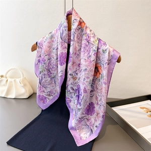 Romantic purple floral silk scarf elegantly draped on a hanger with a minimalist background