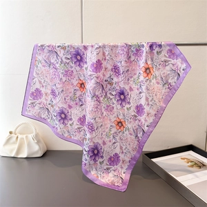 Close-up of purple floral silk scarf hanging to show smooth drape and satin edges
