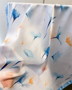 Détail d'un foulard en soie fleurie avec texture douce et bord roulé bleu fini