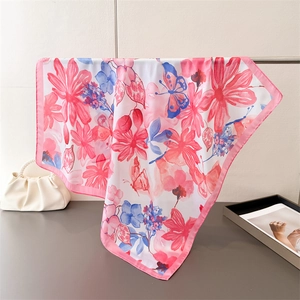 Detailed view of floral silk scarf with pink flowers and blue butterflies on a white base