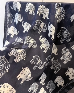 Detail of soft silk-like fabric featuring exotic retro elephant prints in navy and white
