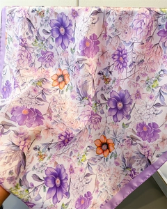 Detailed macro shot of floral silk scarf featuring purple blossoms and satin texture