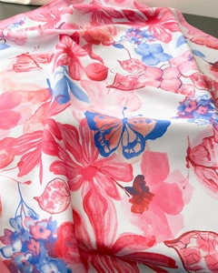 Close-up of silk-textured floral fabric with vibrant pink flowers and blue butterflies