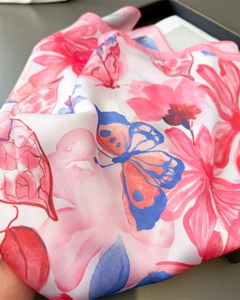 Detail of silk scarf with floral butterfly print and delicate pink rolled edges