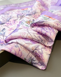 Close-up of floral print silk scarf in purple with elegant satin border and soft texture