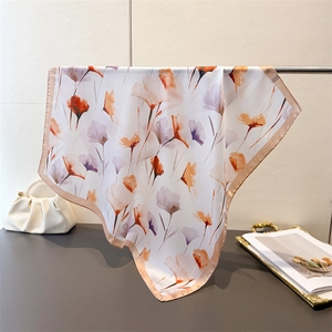 Détail d'un foulard floral en satin avec imprimés aquarelle et texture soyeuse douce