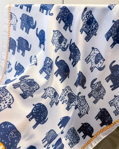 Detailed shot of retro elephant silk scarf with blue patterns and golden chain borders