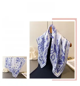 Detail of blue and white silk scarf with floral and bird prints and polka dot borders