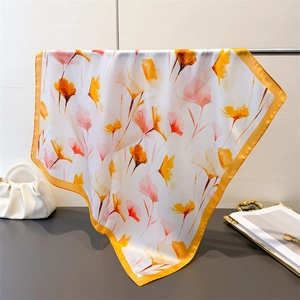 Détail d'un foulard en satin à imprimé coquelicot aquarelle et bordure jaune soyeuse