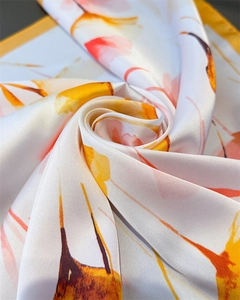 Macro d'un foulard en soie à fleurs abstraites avec textures satinées jaunes et roses