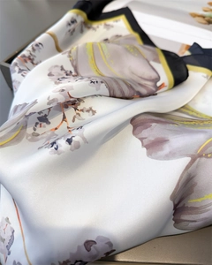 Detailed macro view of soft floral silk scarf with elegant black and yellow borders