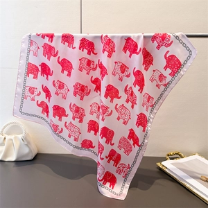 Detail of pink silk-feel scarf featuring red elephant patterns and a chain border design
