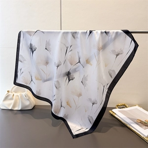 Gros plan d'un foulard en soie synthétique avec motifs floraux sur un support métal
