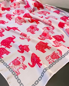 Close-up of pink satin scarf featuring cartoon elephant prints and grey chain borders