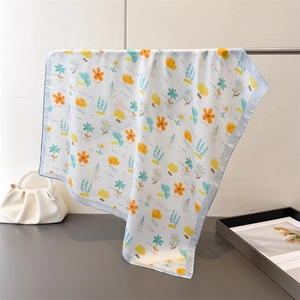 Close-up of floral silk square scarf with light blue border and romantic text print