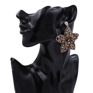 Boucles d'oreilles étoile faites main avec cristaux gris et perles dorées sur mannequin