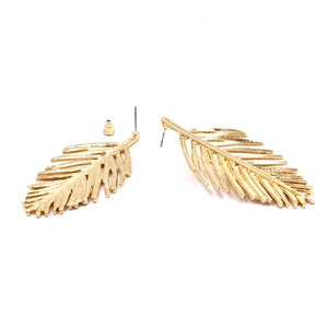 Detailed view of golden leaf-shaped earrings showing realistic vein textures and metallic shine