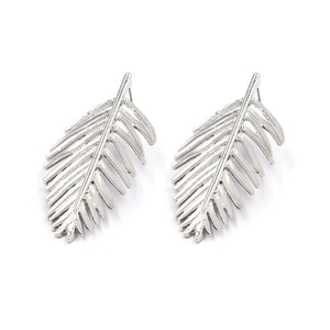 Detailed macro view of silver palm leaf earrings with intricate hollowed-out vein patterns