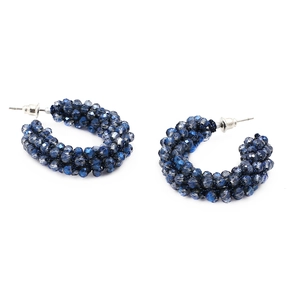 Detail of C-shaped hoop earrings featuring dark blue faceted crystal beads with silver posts