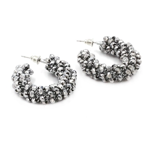 Detailed view of bohemian C-shaped earrings with grey faceted beads and metal posts