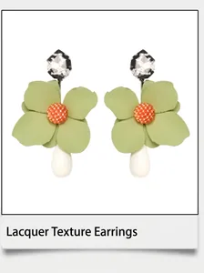 Detail of floral earrings with green enamel petals and white teardrop pearls