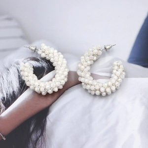 Detailed view of bohemian white faceted crystal bead woven C-shaped hoop earrings