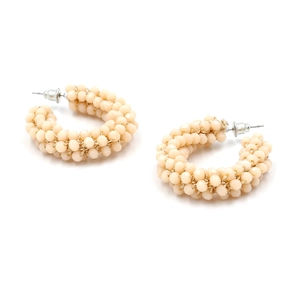 Close-up of Bohemian C-shaped beaded earrings with cream faceted beads and gold wire