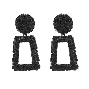 Matte black geometric earrings with embossed floral texture on a minimalist metal frame