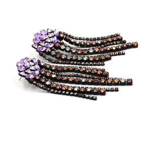Detail of long fringe rhinestone earrings with purple and brown crystal tassels