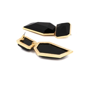 Detail of geometric resin earrings with black polyhedrons and gold metal frame