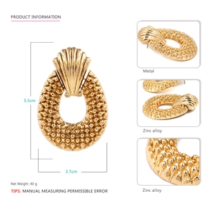 Detailed view of vintage oval alloy earrings with spike texture and 5.5cm size mark