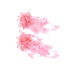 Dettaglio di orecchini fatti a mano con perline rosa, nappine e accenti in cristallo