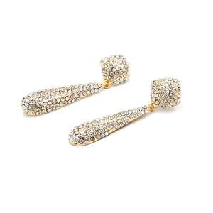 Détail de boucles d'oreilles pendantes dorées avec strass brillants et design goutte