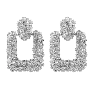Detailansicht silberner geometrischer Ohrringe mit feinen Sternblumenrelief-Texturen