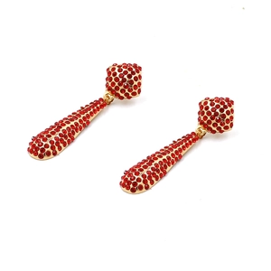 Détails macro d'élégantes boucles d'oreilles en forme de larme avec strass rouges et or